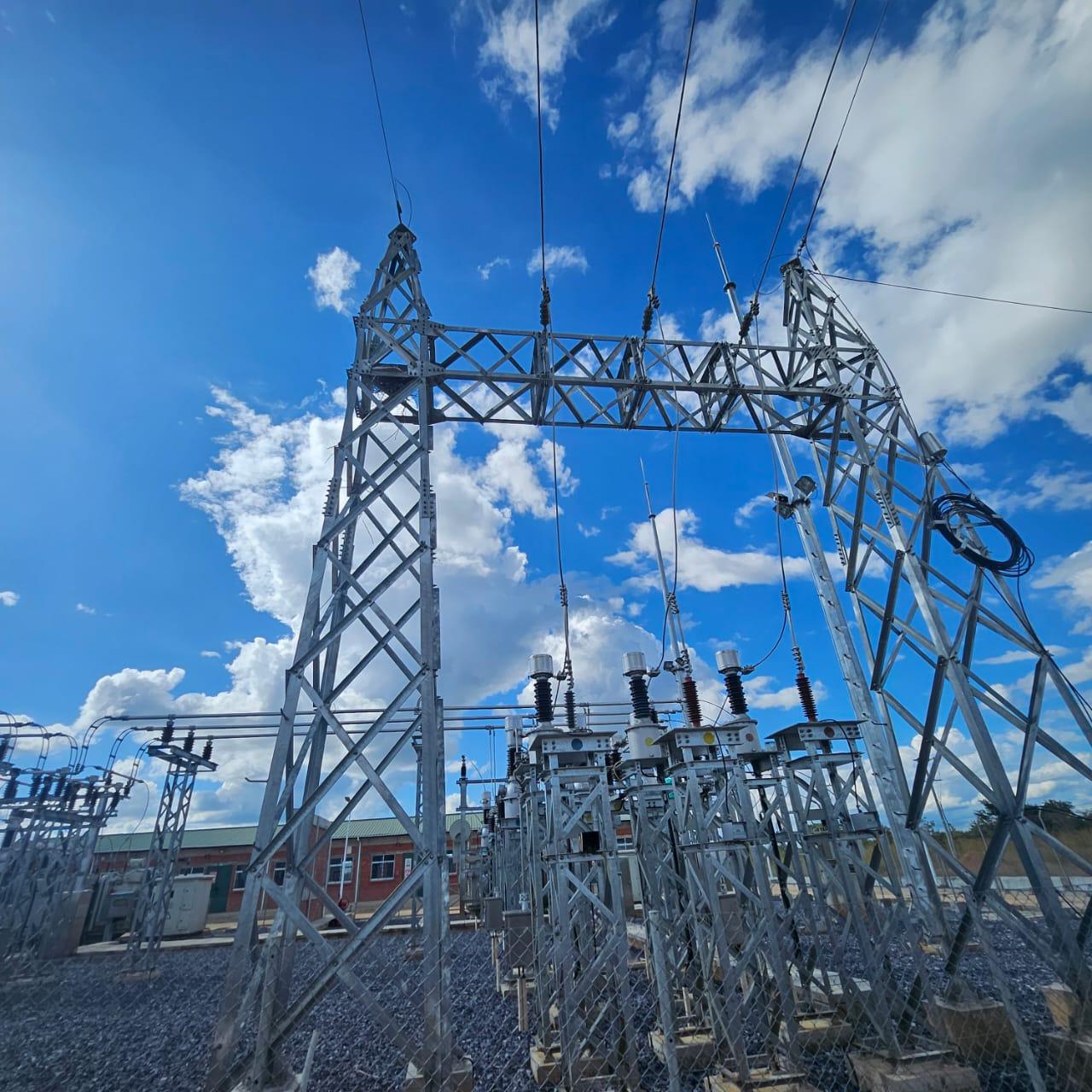 High-voltage substation gantry against a blue Zambian sky