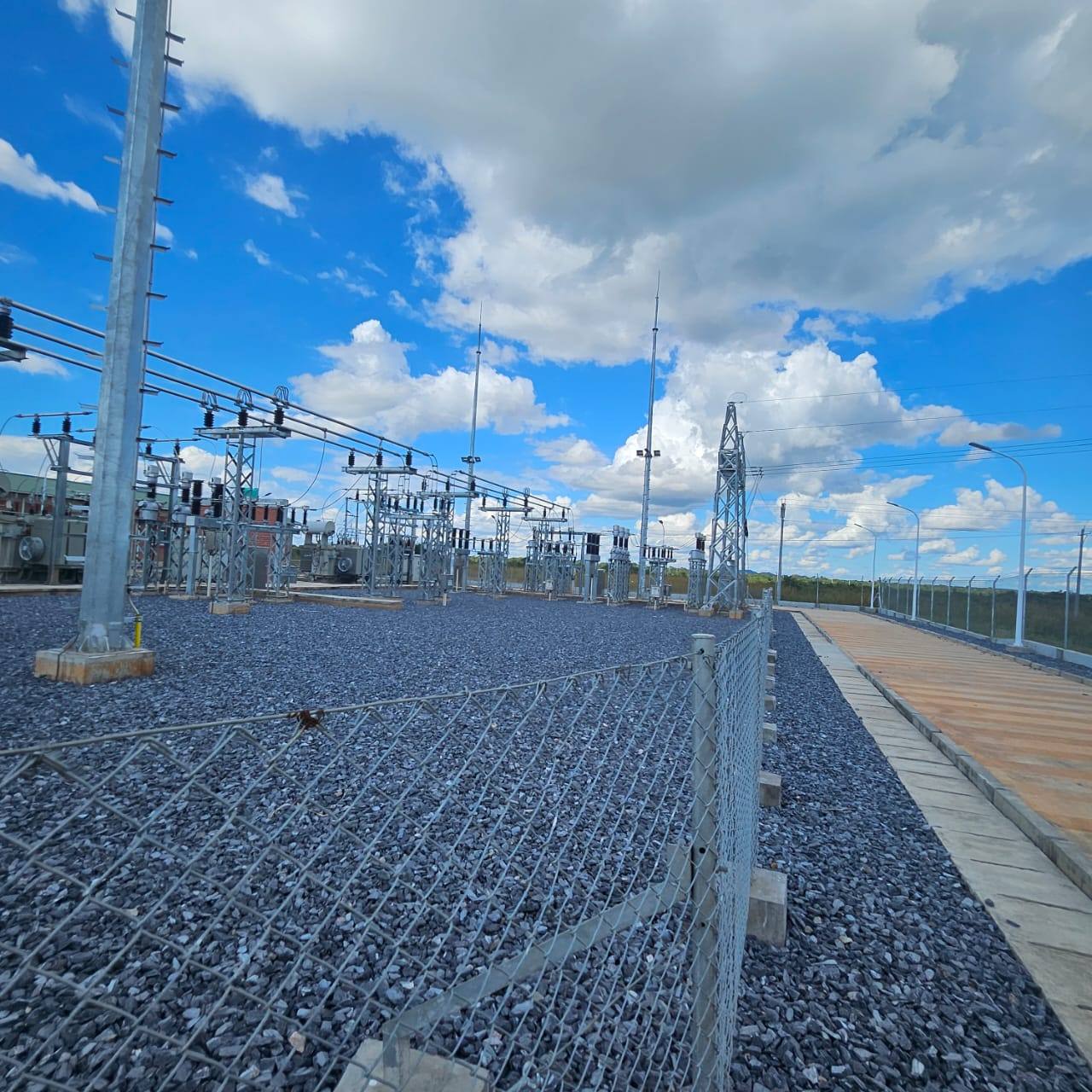 Substation yard with transformer bays under a blue sky